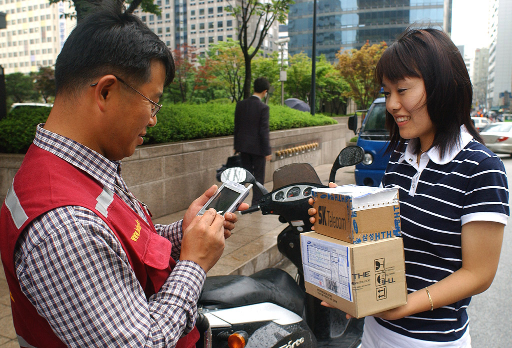 A delivery staff member is shown holding a PDA for the Jet Rider service.